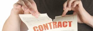 person tearing apart contract paper